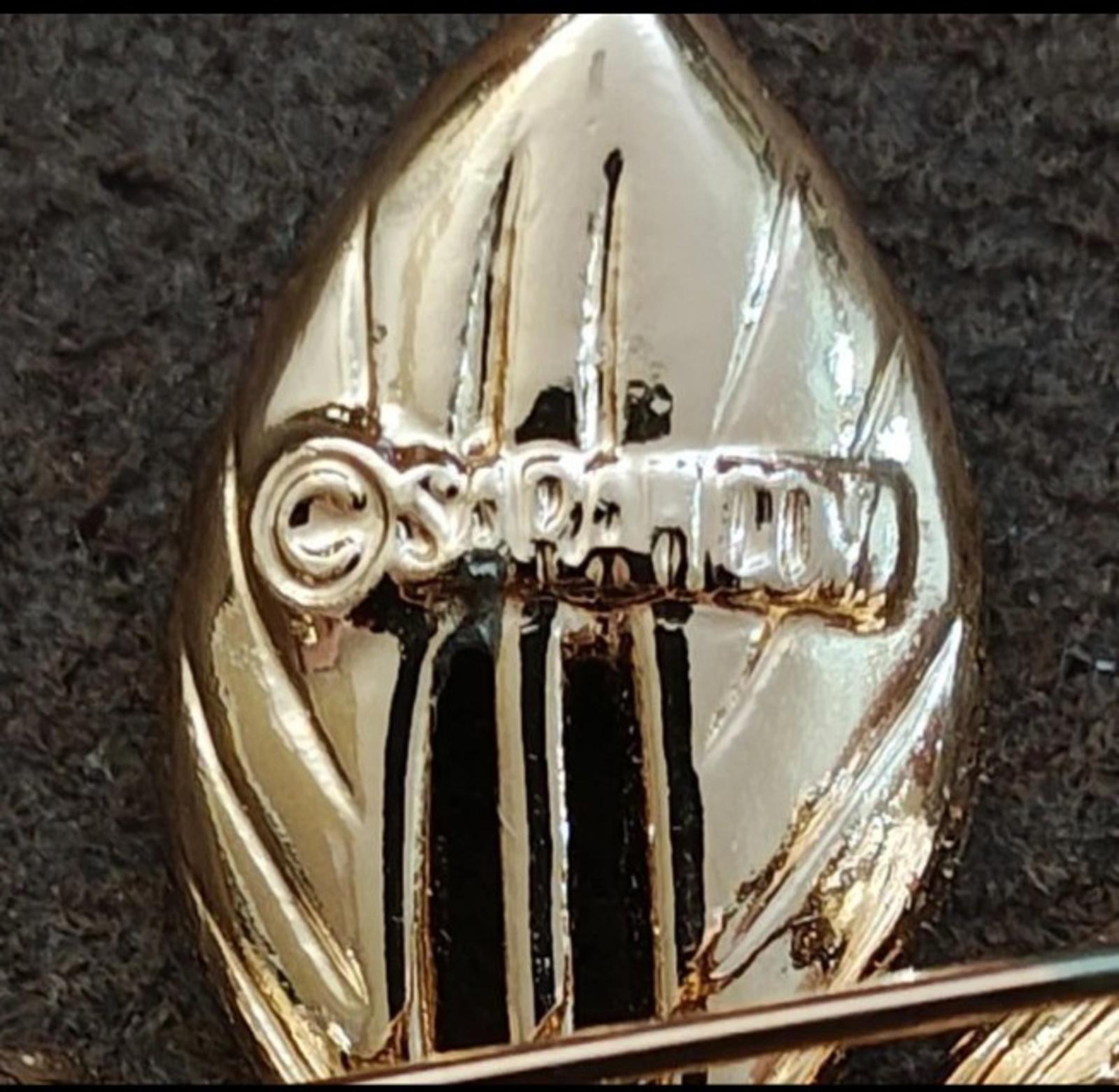 Close-up of gold-tone brooch back with vertical ridges and clasp area detail