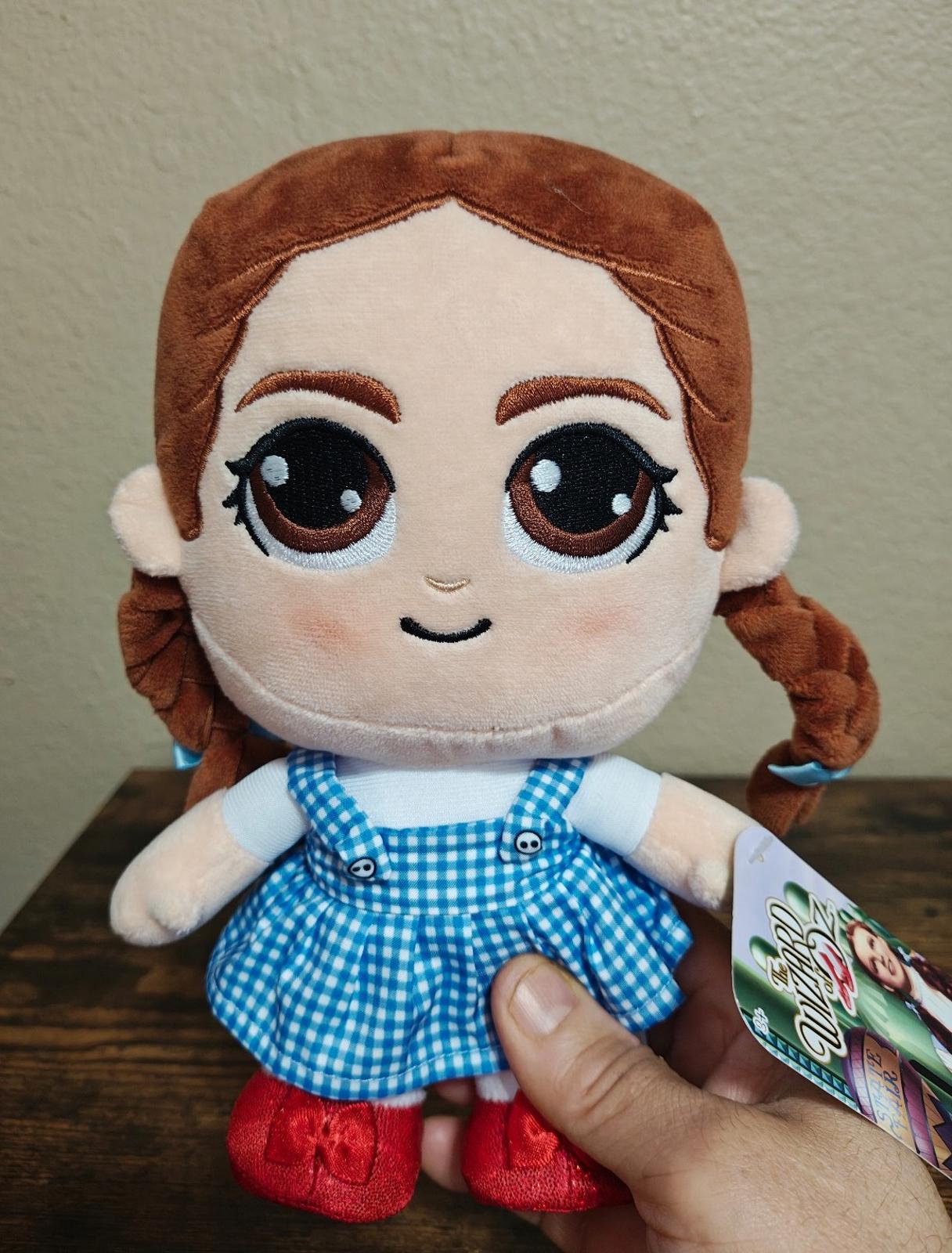 Dorothy-style plush doll front view, blue gingham dress, red shoes, green hangtag