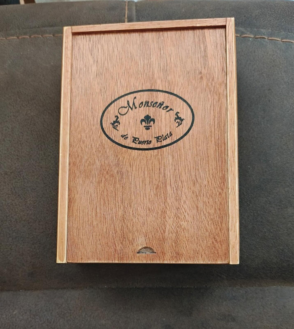 Wooden cigar box, closed, with centered oval brand label on the lid