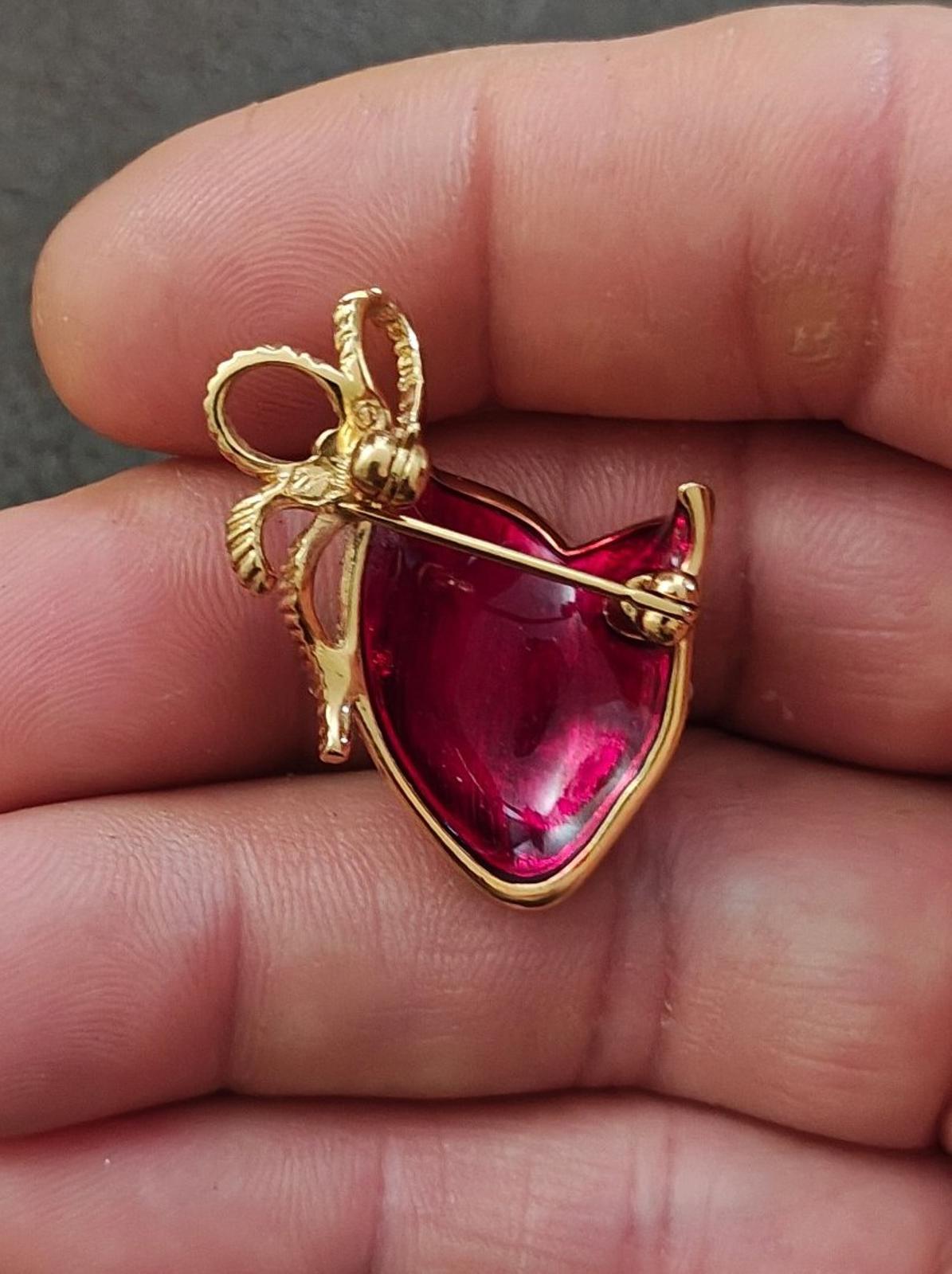 Back/side view of gold-tone cat mask brooch with red gemstone-style center and pin post