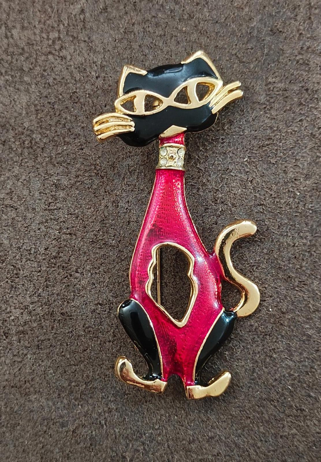 Red and black enamel cat mask brooch with gold-tone detailing, standing pose.
