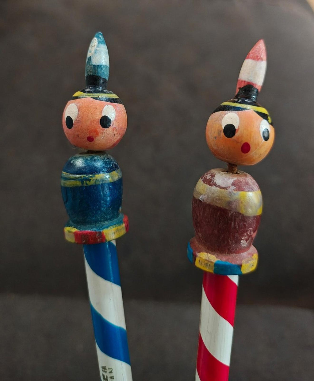 Decorative wooden pencils with painted owl faces; blue-and-white and red-and-white striped bodies.