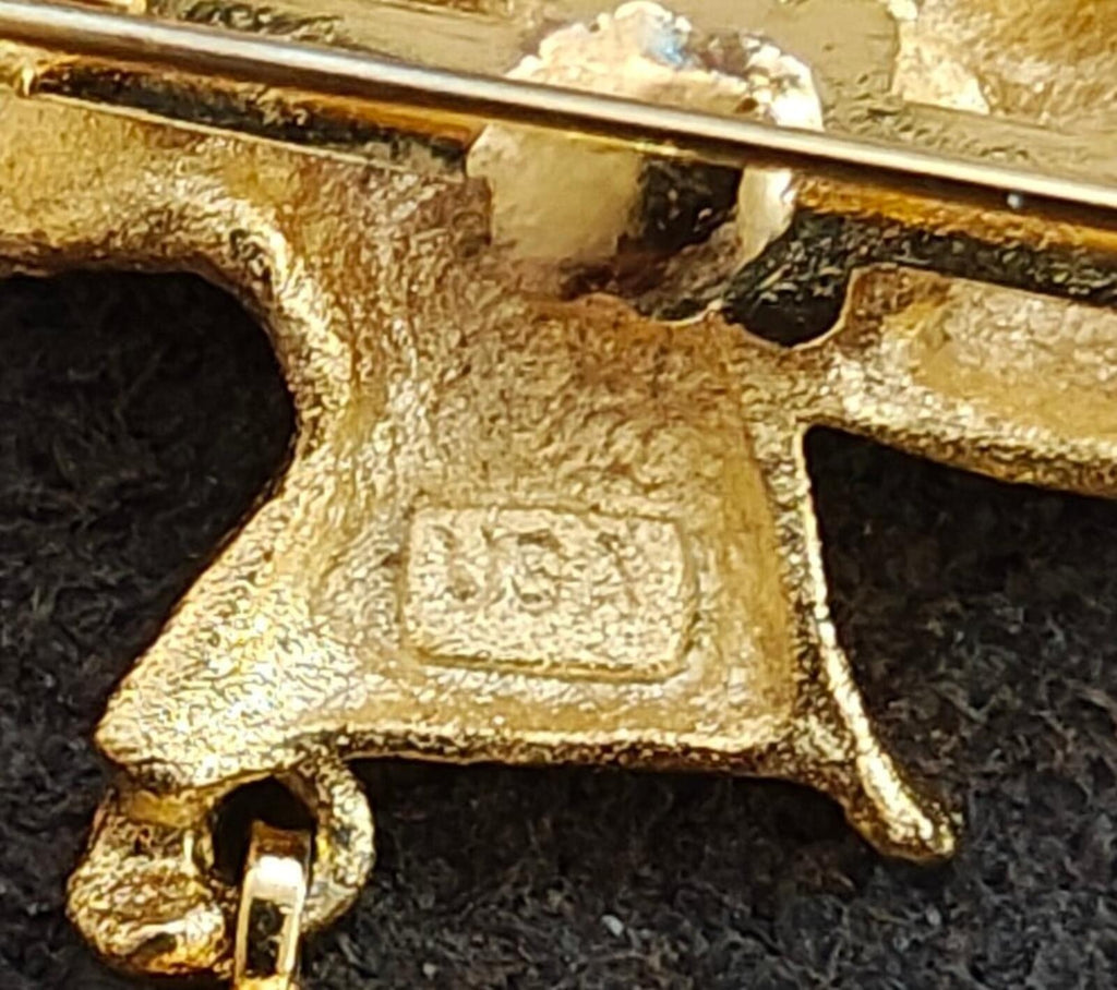 Gold-tone angel brooch clasp and pin mechanism, close-up detail