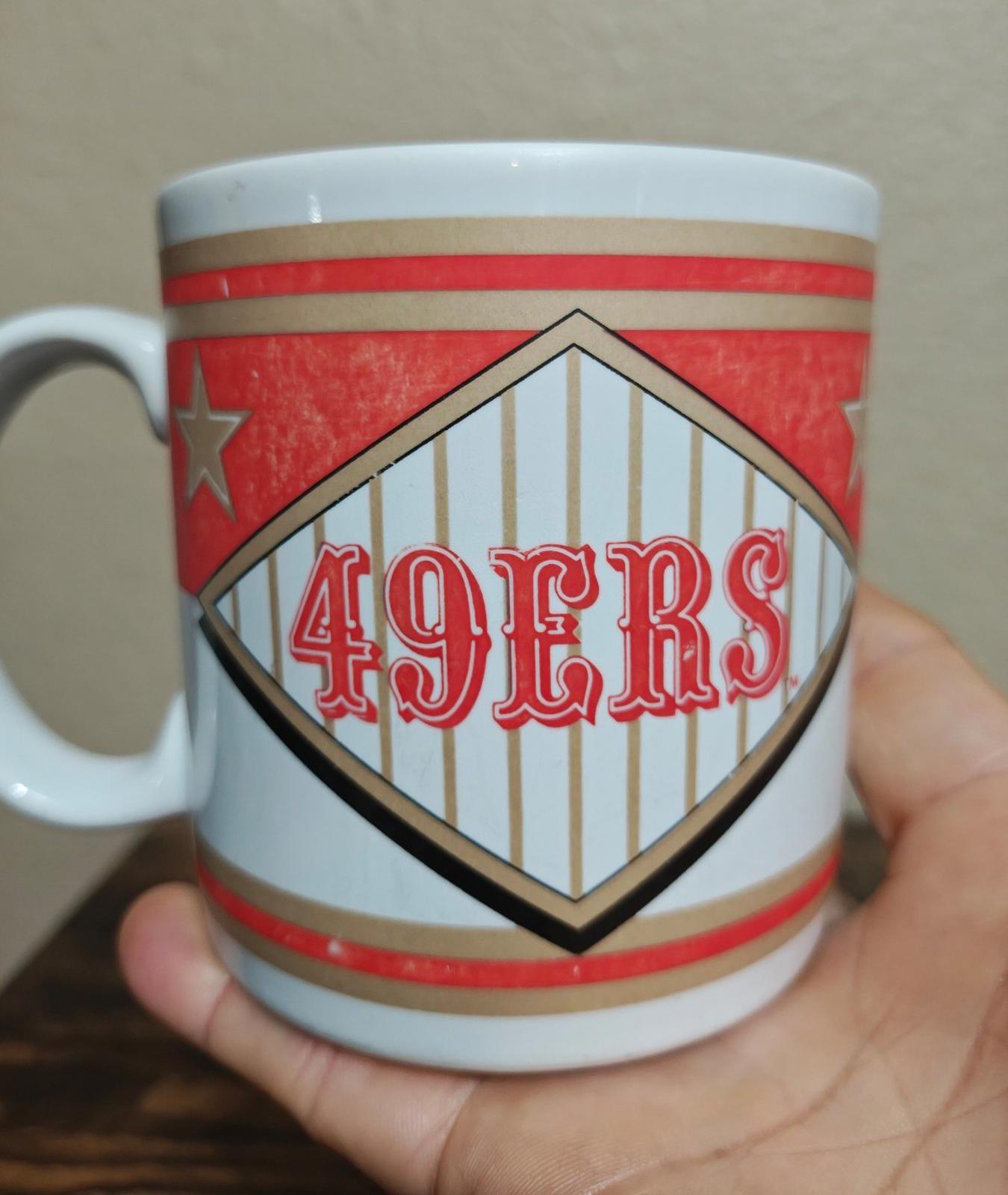 San Francisco 49ers “49ERS” diamond logo mug with red-and-white striped border.