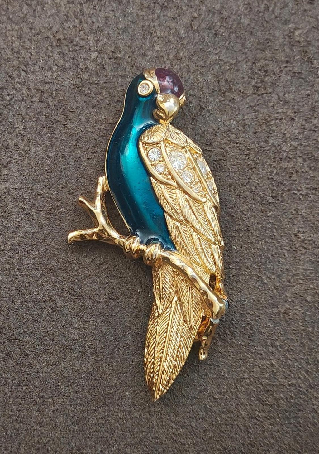 Gold tone enamel bird brooch, angled view with teal enamel and sparkling rhinestone pattern