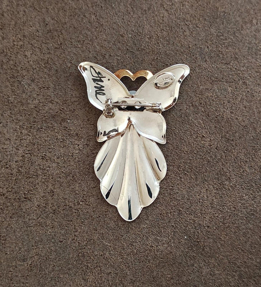 Silver angel pin with faux pearl and gold heart halo; pin clasp visible at back