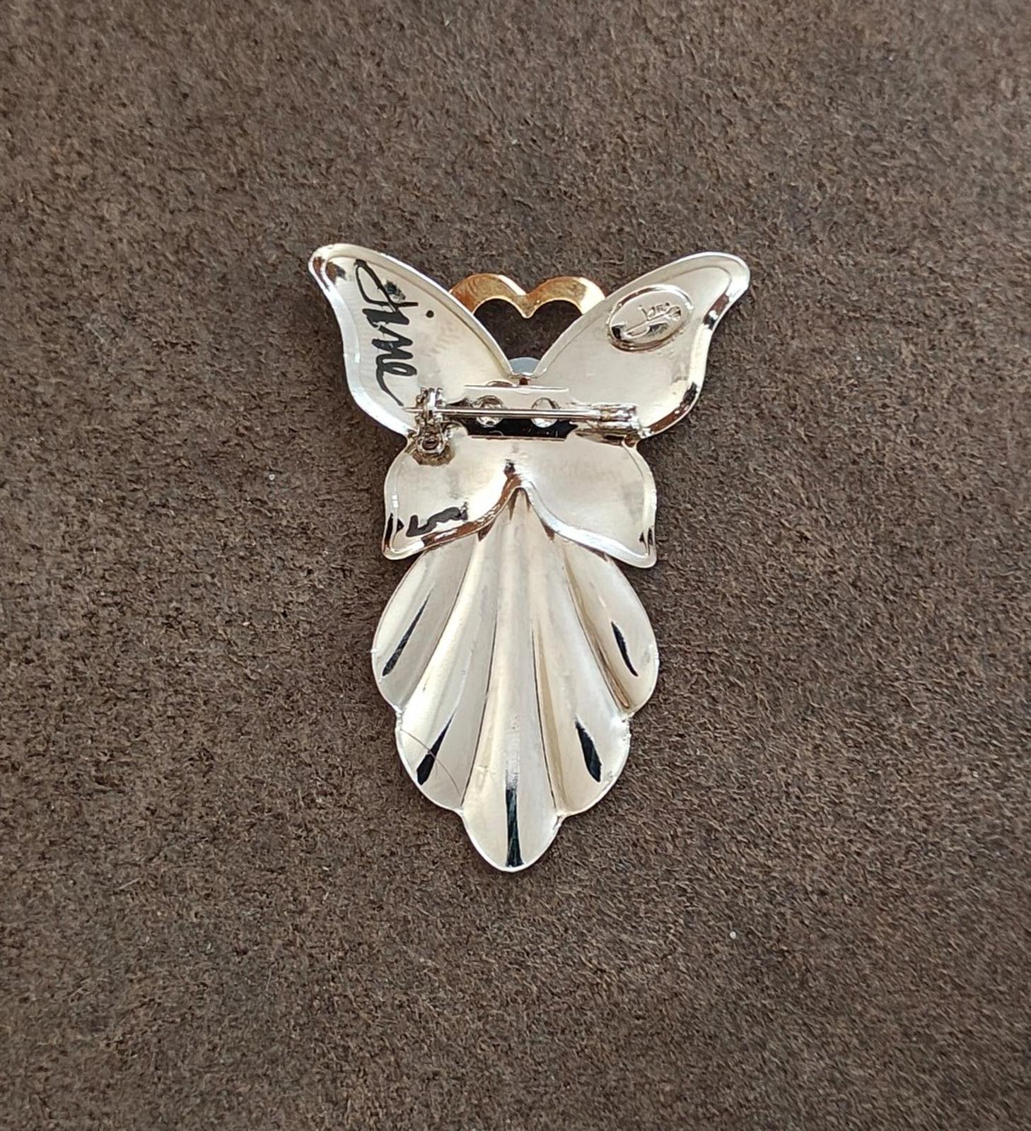 Silver angel pin with faux pearl and gold heart halo; pin clasp visible at back