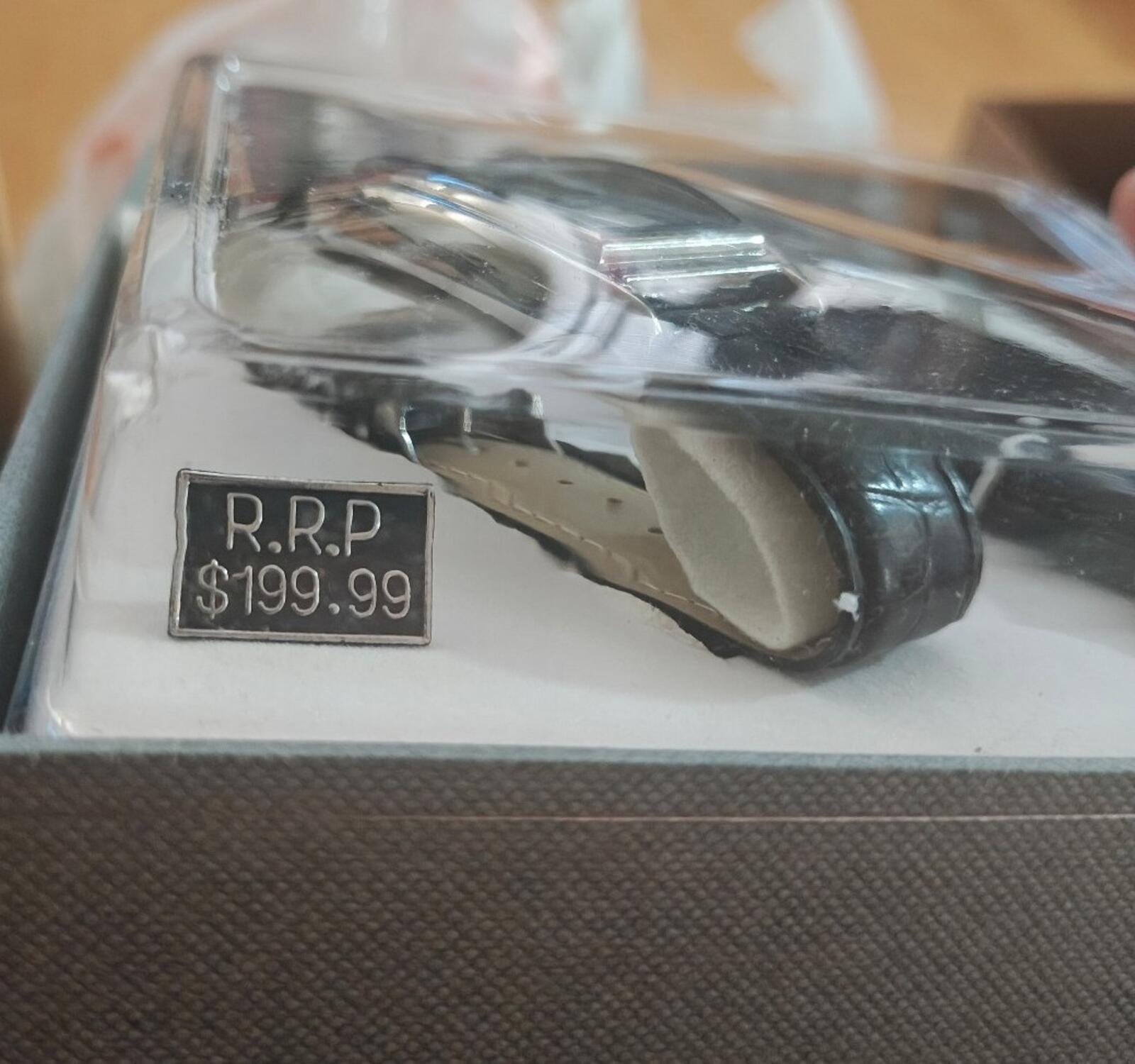 Sealed watch and pen set with price tag reading “R.R.P $199.99”.