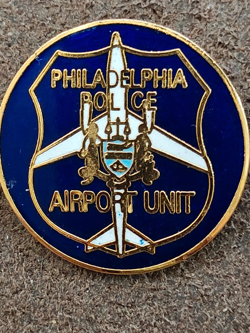 Large close-up of blue and gold Philadelphia Police Airport Unit round lapel pin