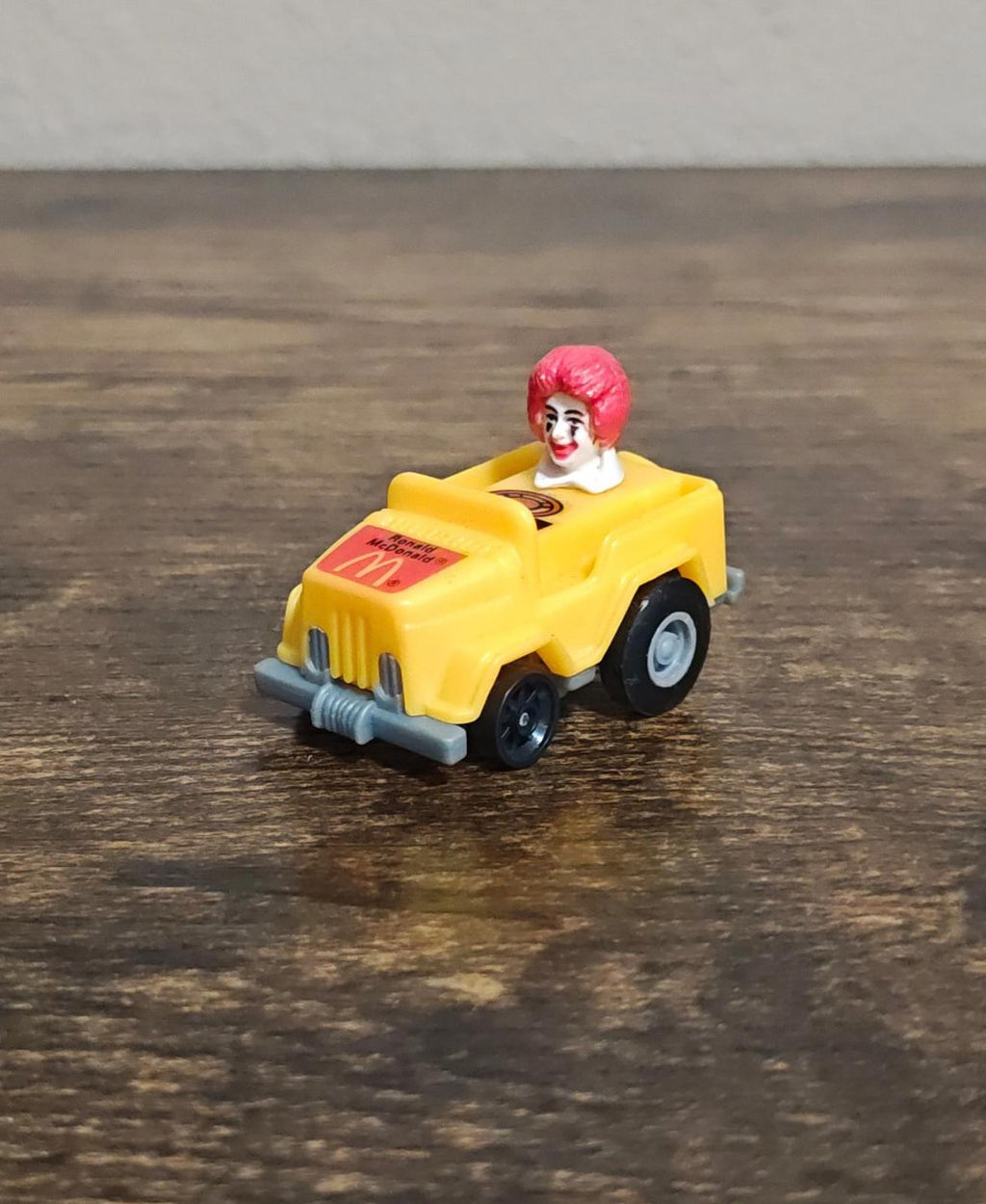 Yellow toy runabout car with Ronald McDonald figure, front-left corner view