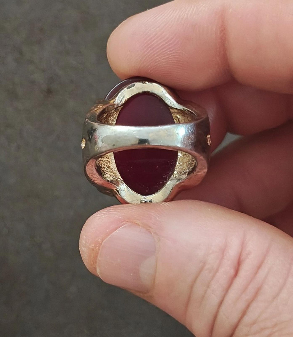 Red oval faux stone ring with gold-tone openwork back and curved metal frame