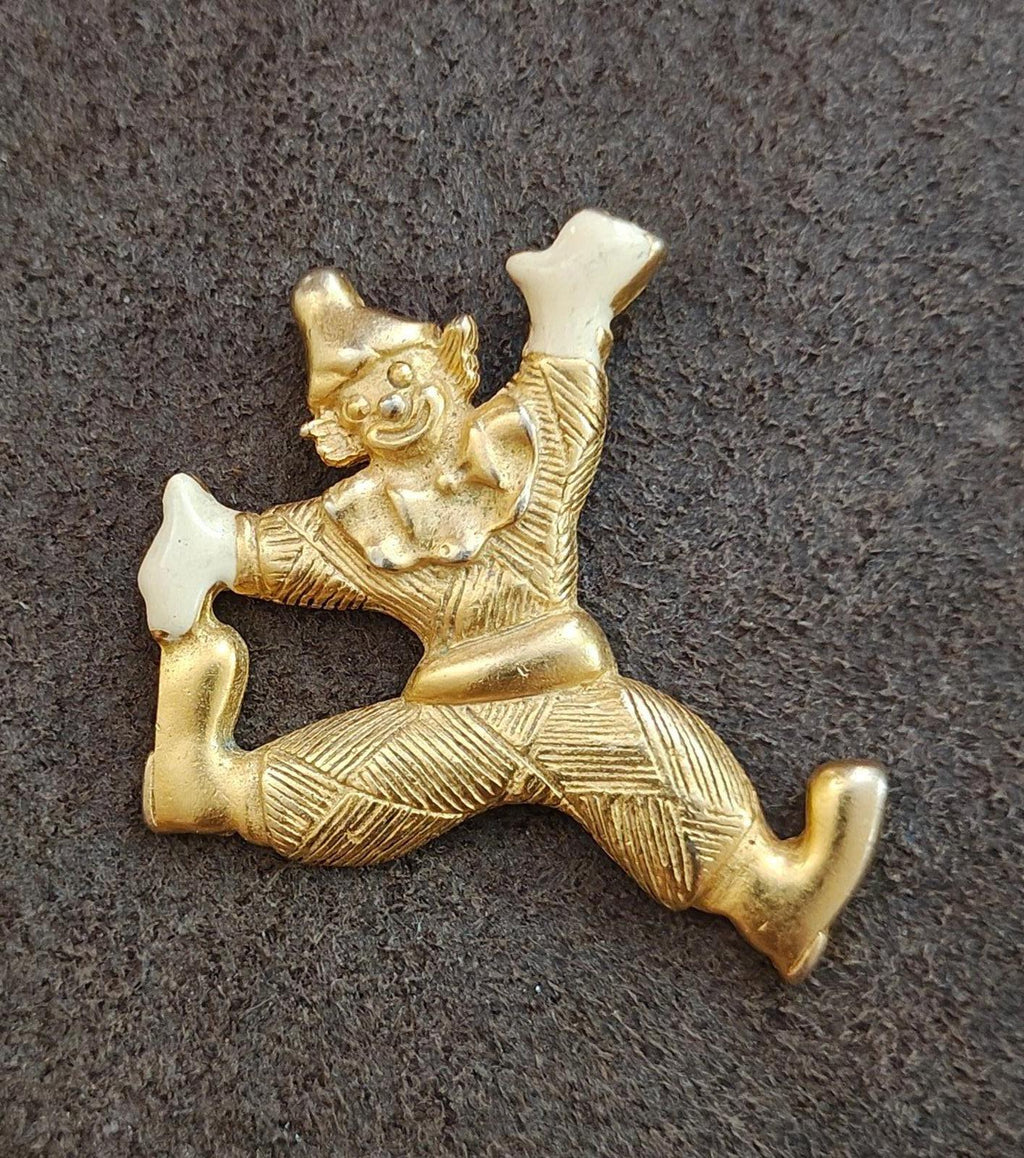 Gold tone clowning around pendant with white enamel shoes, straight-on view with curled feet