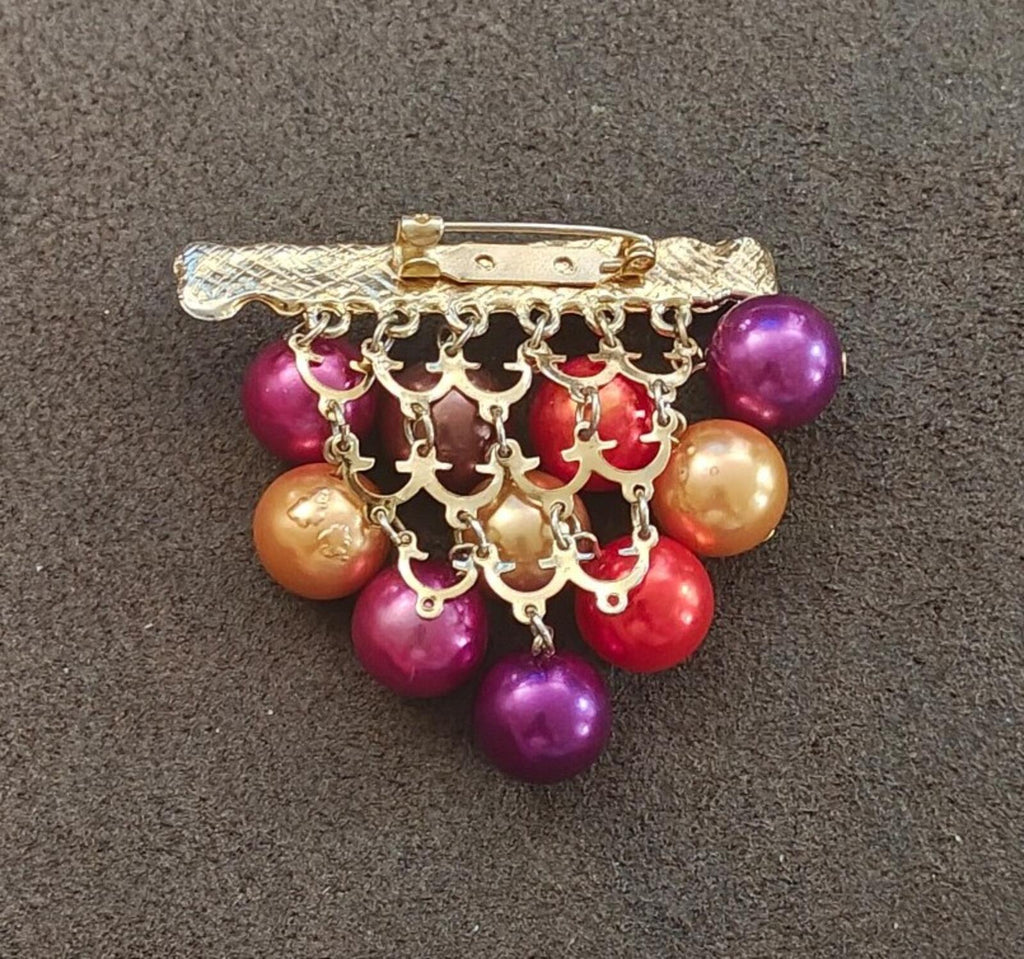 Gold-tone chandelier brooch with dangling purple, red, and gold beads from bar