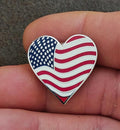 Heart-shaped enamel flag pin with blue stars and red/white wavy stripes, silver border
