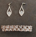 Crystal teardrop stud earrings with light blue center stones in silver-tone settings