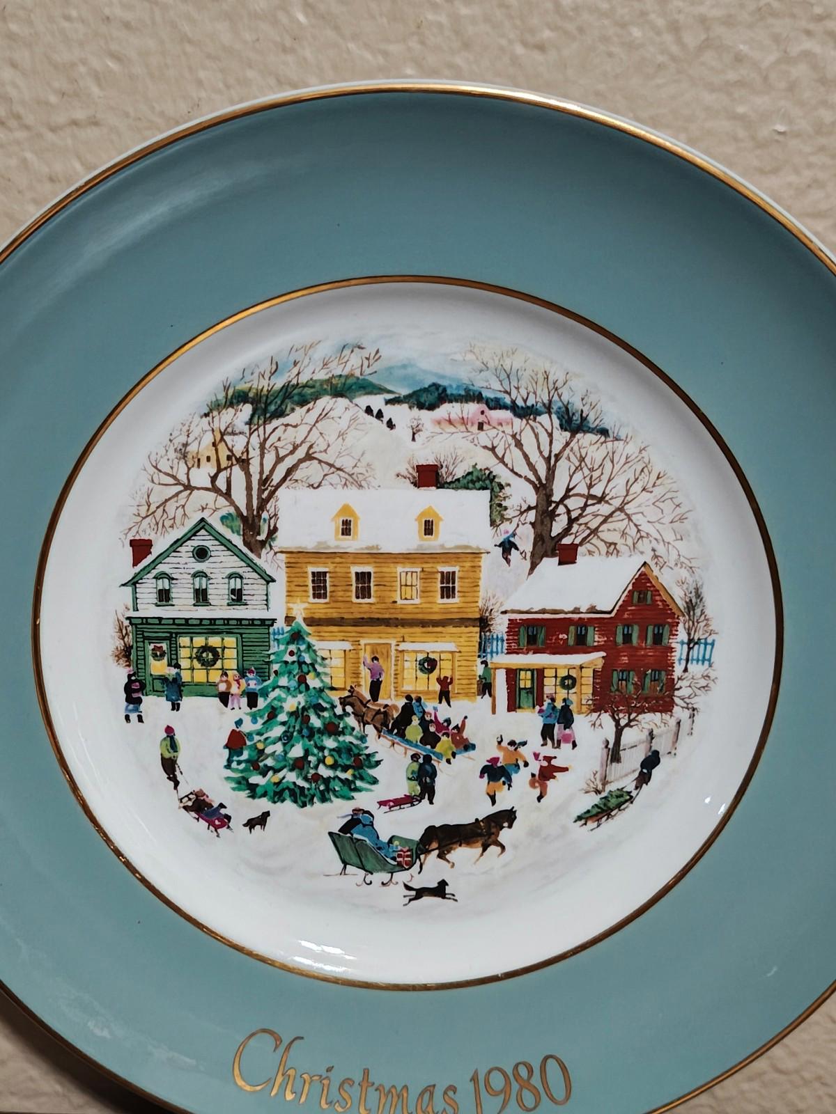 Light blue porcelain plate close-up with 1980 village scene and gold-trimmed inner border