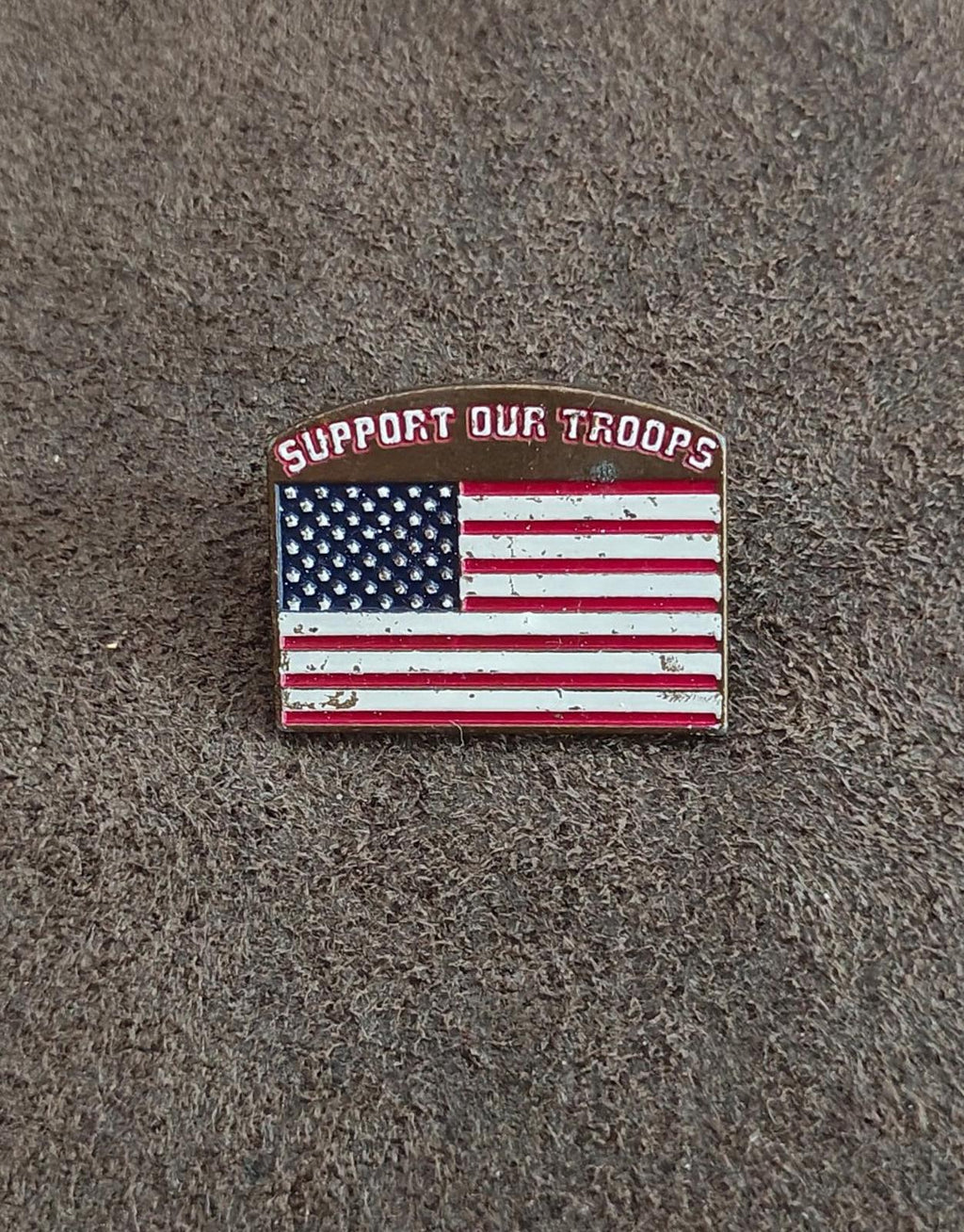 Gold-tone enamel pin with U.S. flag stars and stripes; “Support Our Troops” text