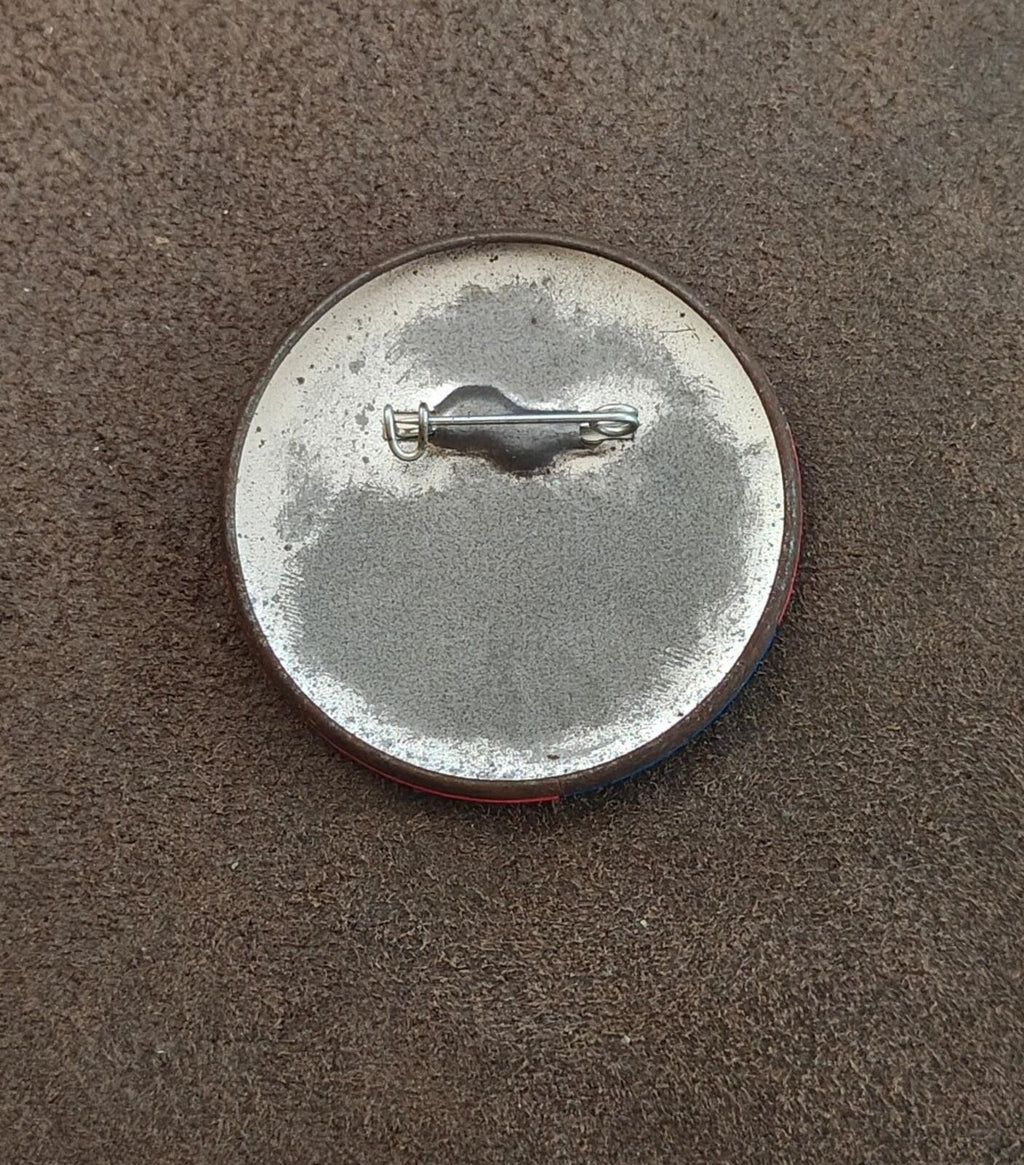 Silver back of a button pin with metal pin clasp