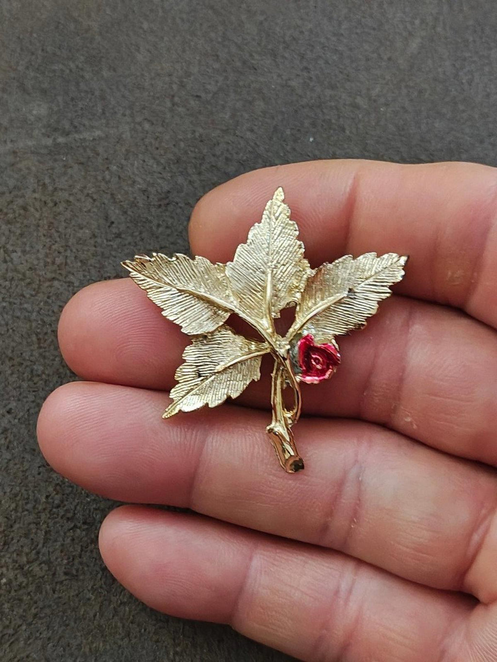Gold-tone leaf cross pin brooch with red rose, Mary medallion on hand