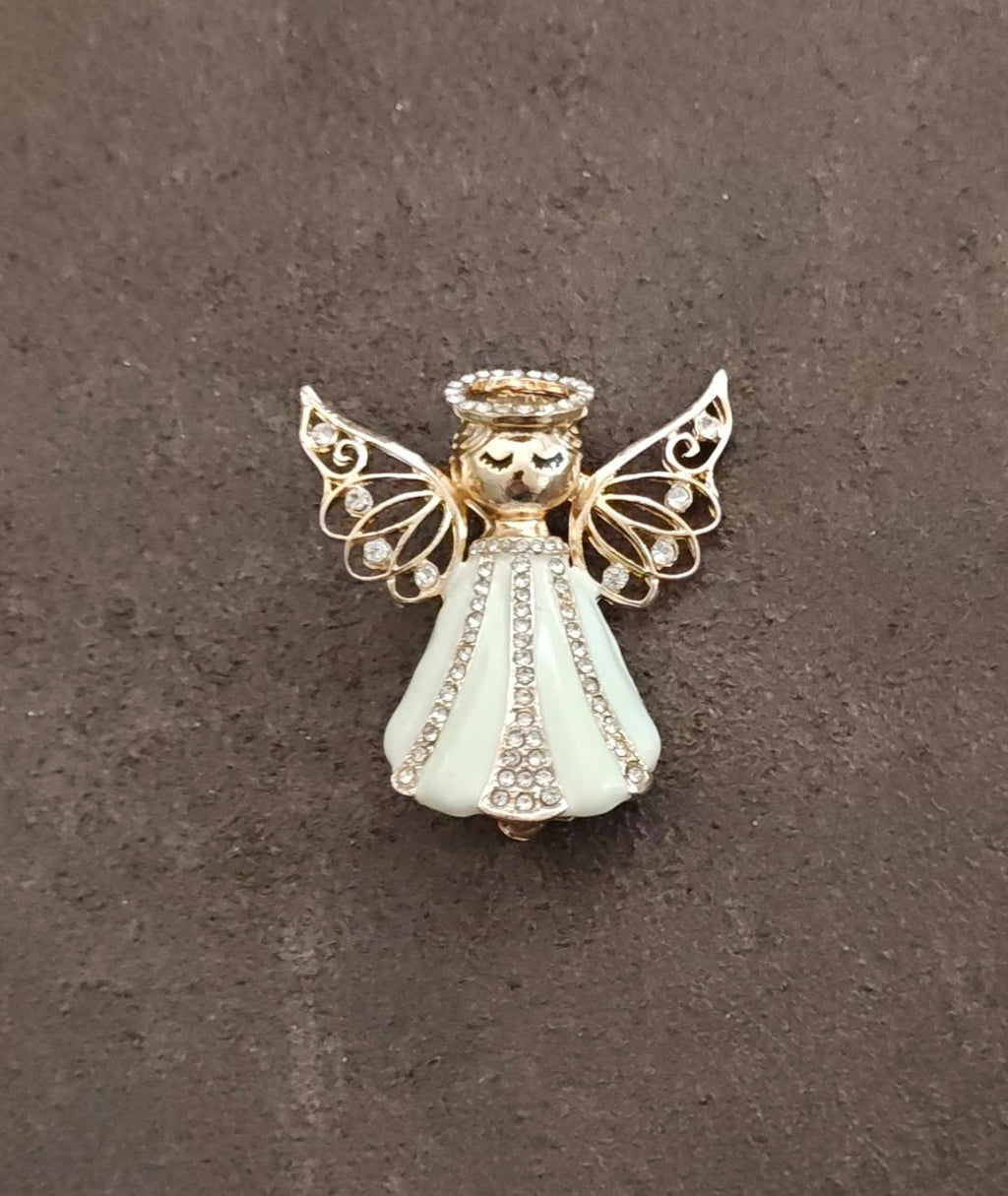 Gold tone angel brooch with beaded halo, cream enamel dress, and scrollwork wings