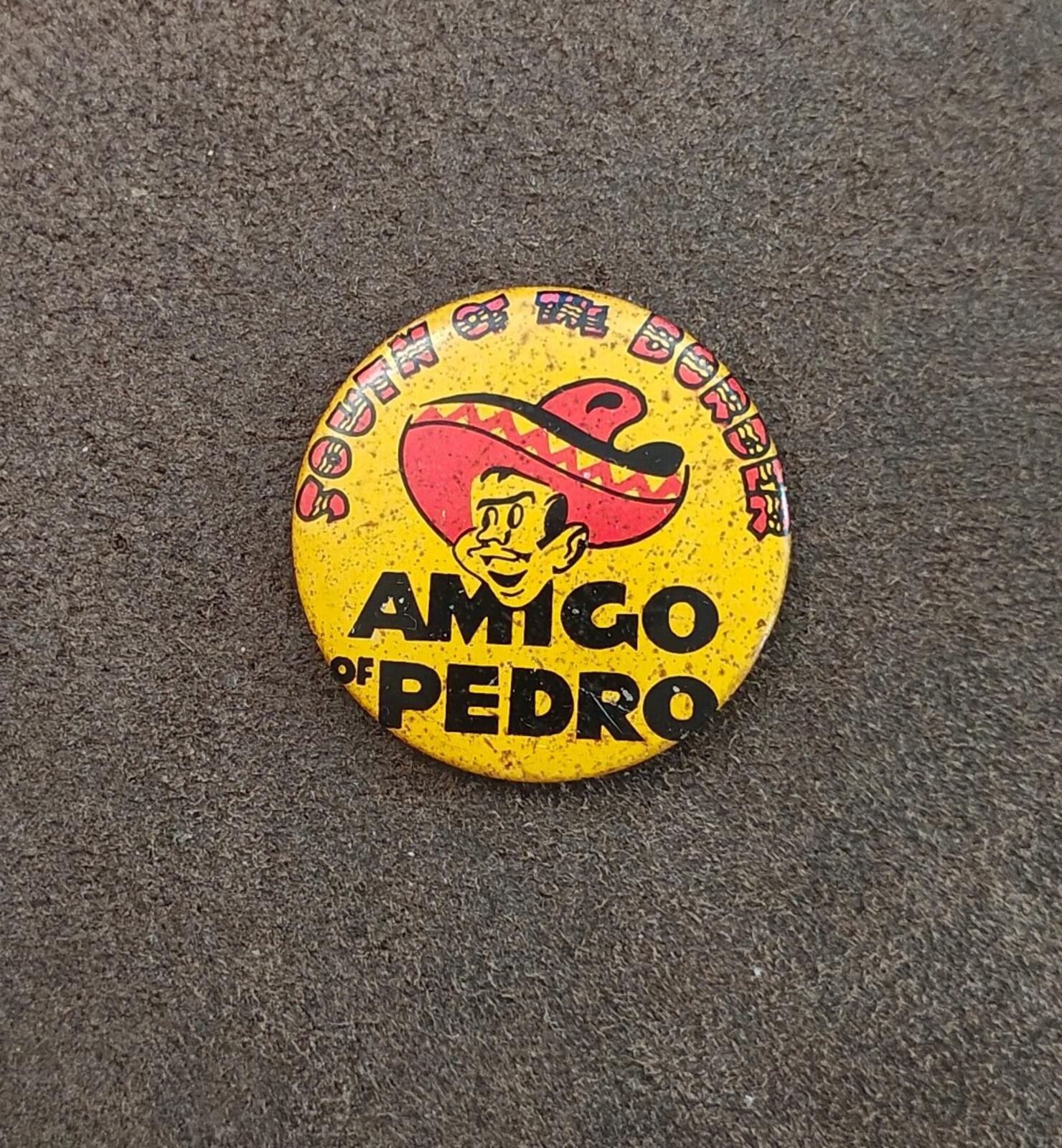 Centered yellow AMIGO OF PEDRO pinback button with sombrero mascot graphic on gray surface