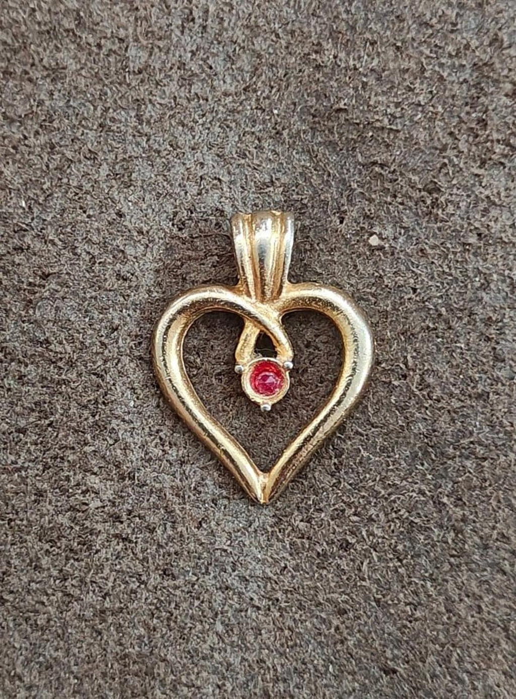 Gold-tone open-heart pin with red gemstone, centered pendant style