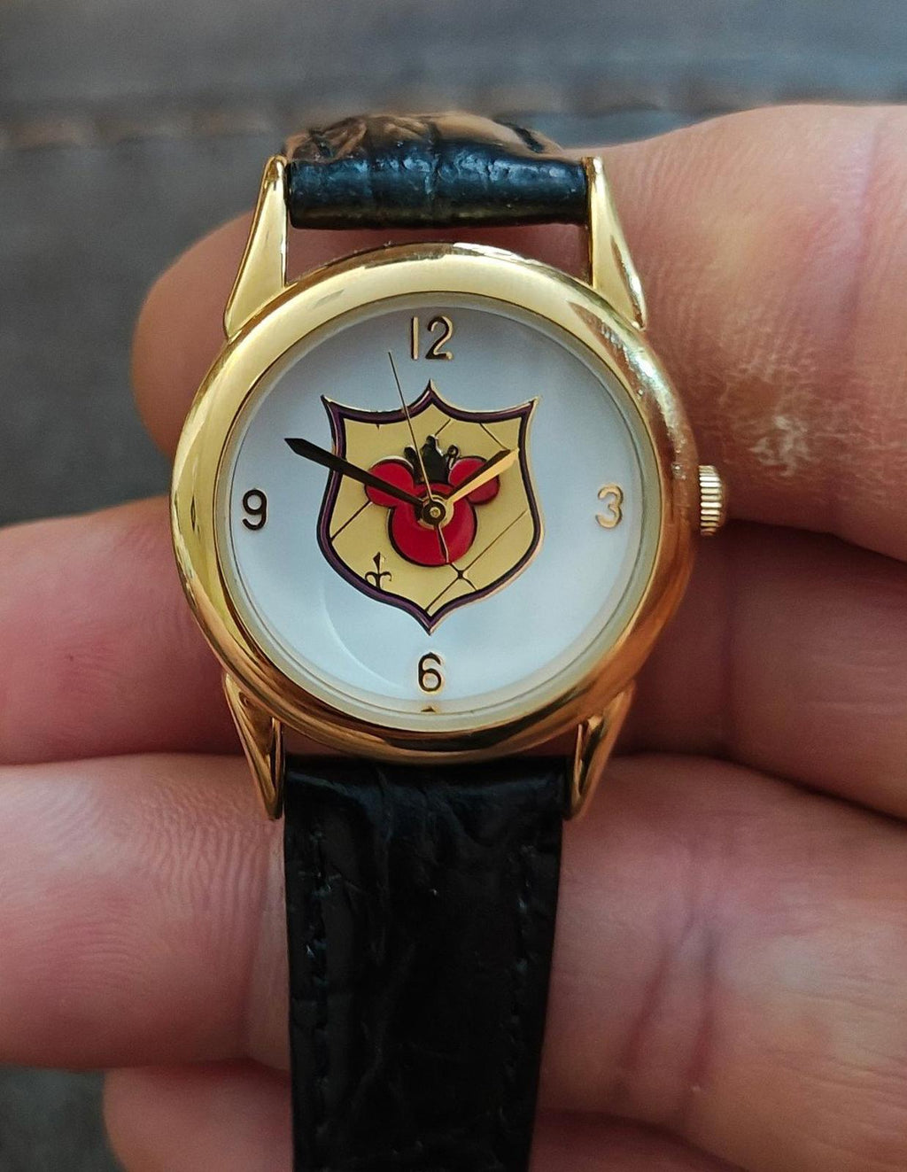Gold-tone quartz wristwatch with black leather strap and Mickey-style red dial logo.