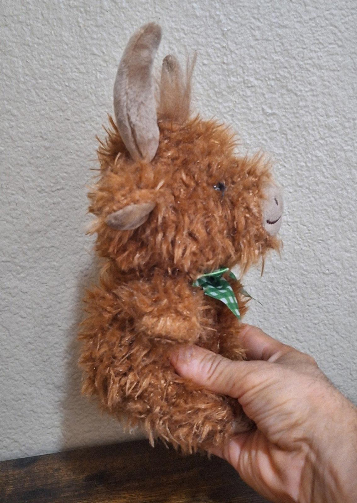 Brown Easter shaggy bull plush with small horns, green gingham bow, held upright