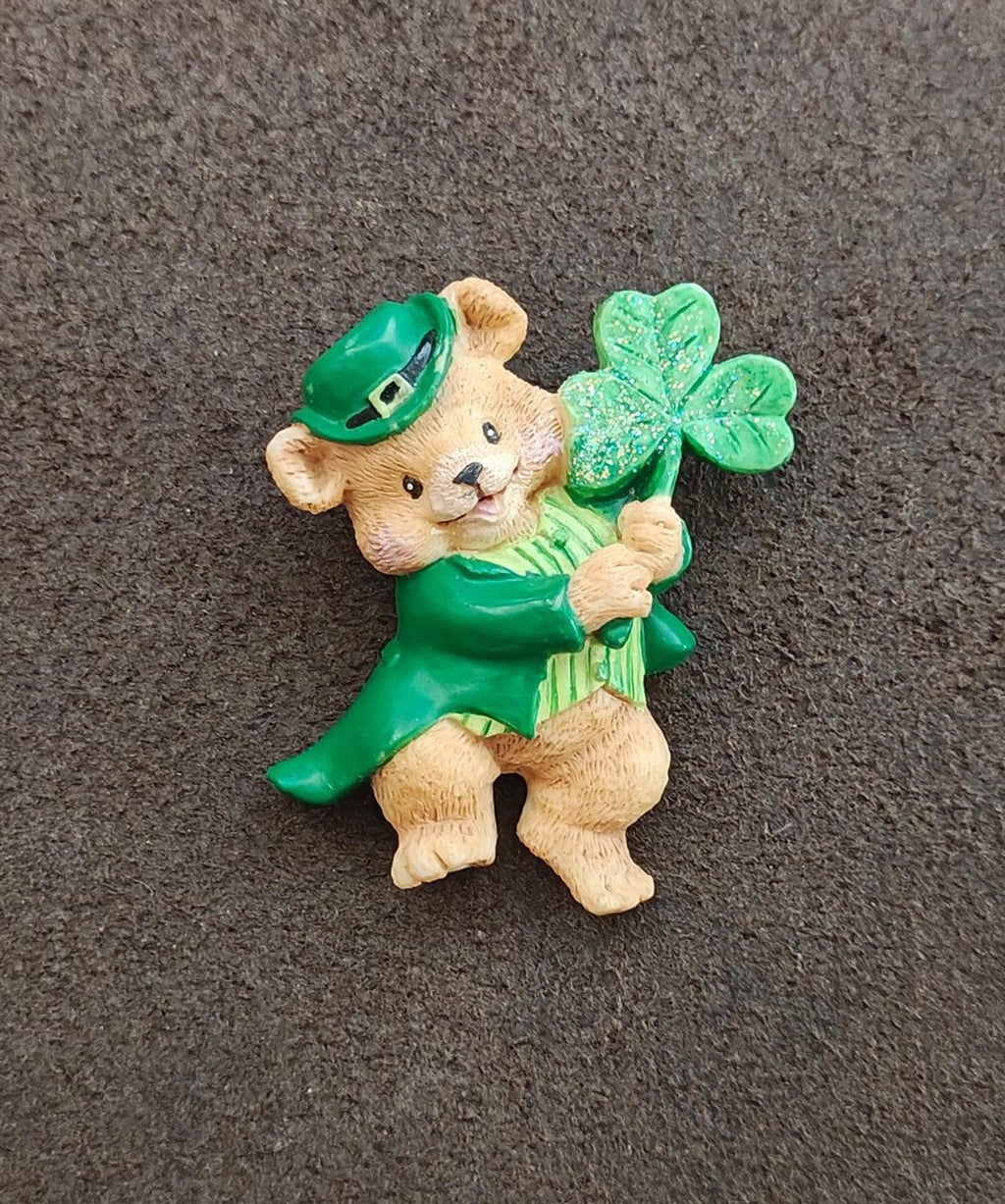 Green bear leprechaun brooch standing with a shamrock bouquet