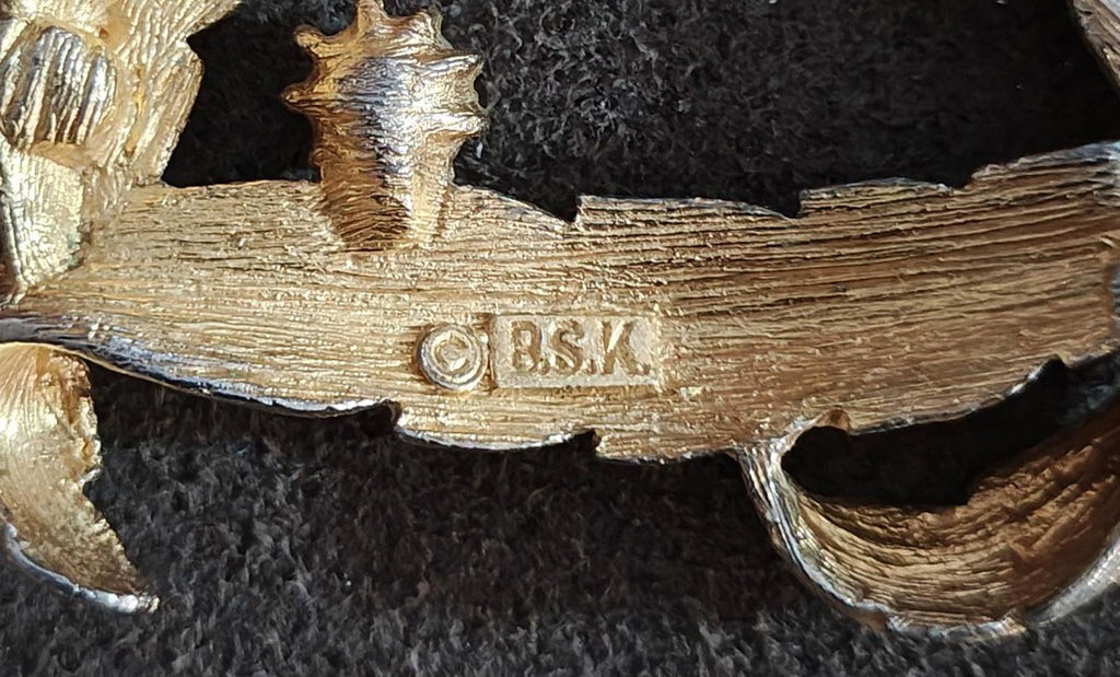 Close-up of BSK hallmark on gold-tone letter D monogram pendant