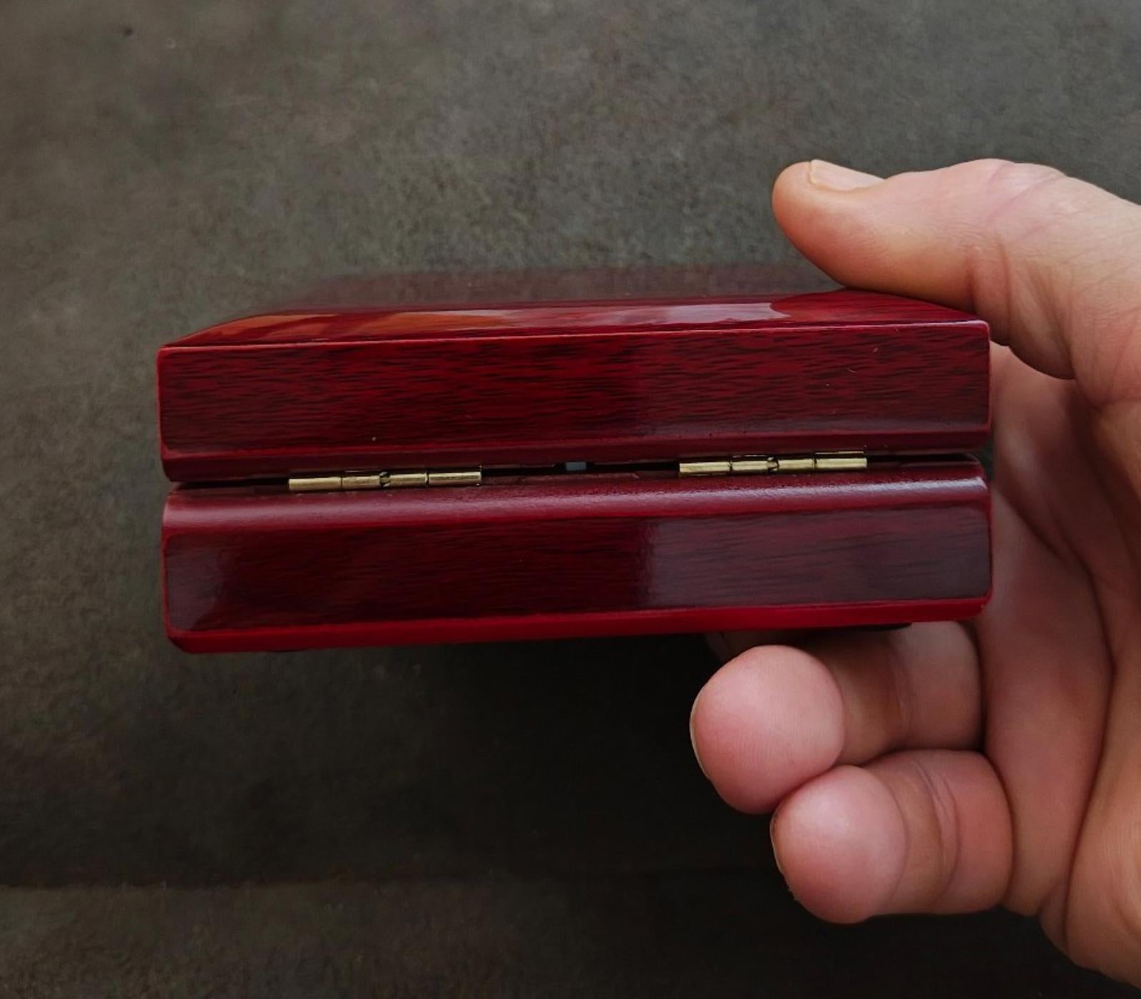 Red jewelry gift box with lid slightly open and velvet insert