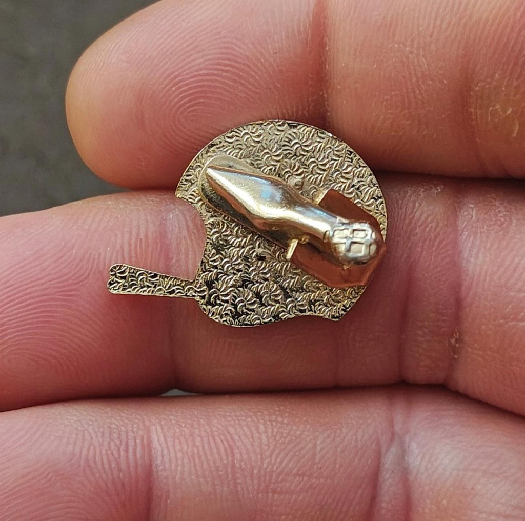 Gold-tone enamel tie clip back with textured gold oval and hinge bar