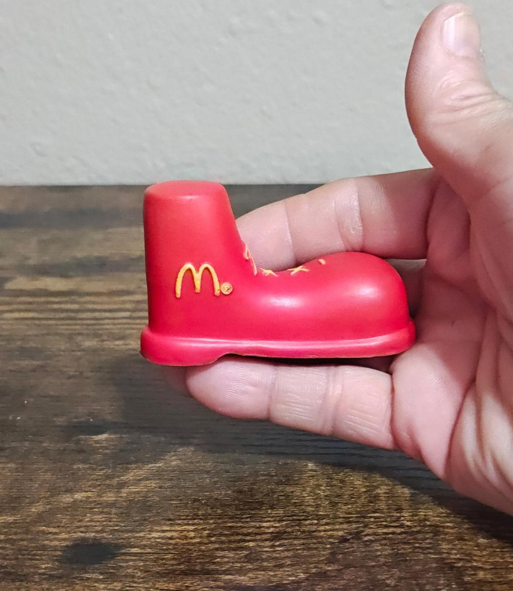 Red shoe antenna topper figurine with gold McDonald's logo and yellow trim details