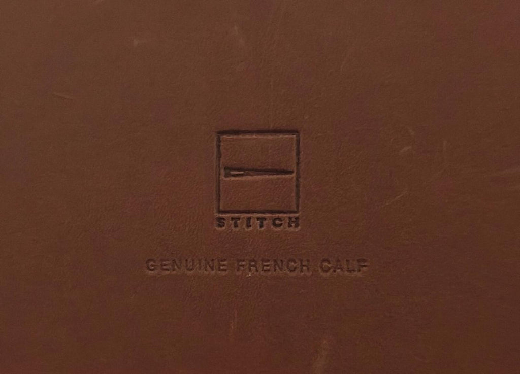 Brown leather album cover close-up with embossed logo and text