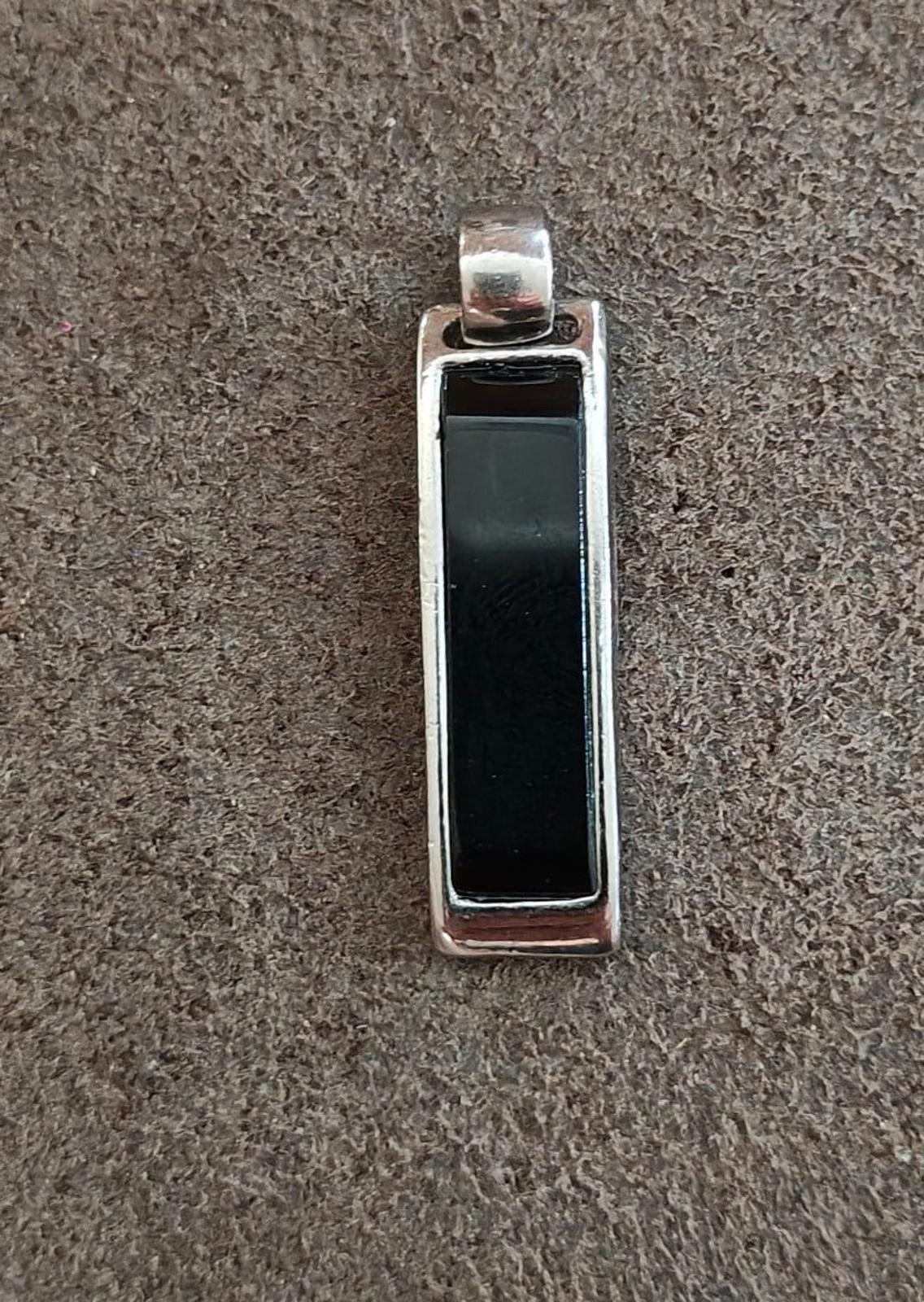 Silver-tone rectangular slide pendant, black inlay front view on textured background.