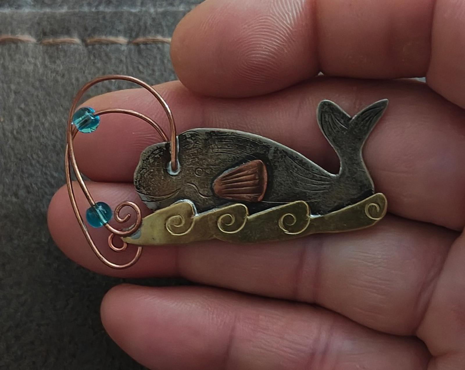 Gold-tone whale brooch pin with blue stones, copper wire swirls, dark green enamel body