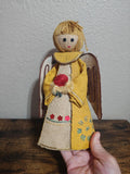 Handcrafted burlap angel doll with yellow dress, brown wings, and yarn hair.