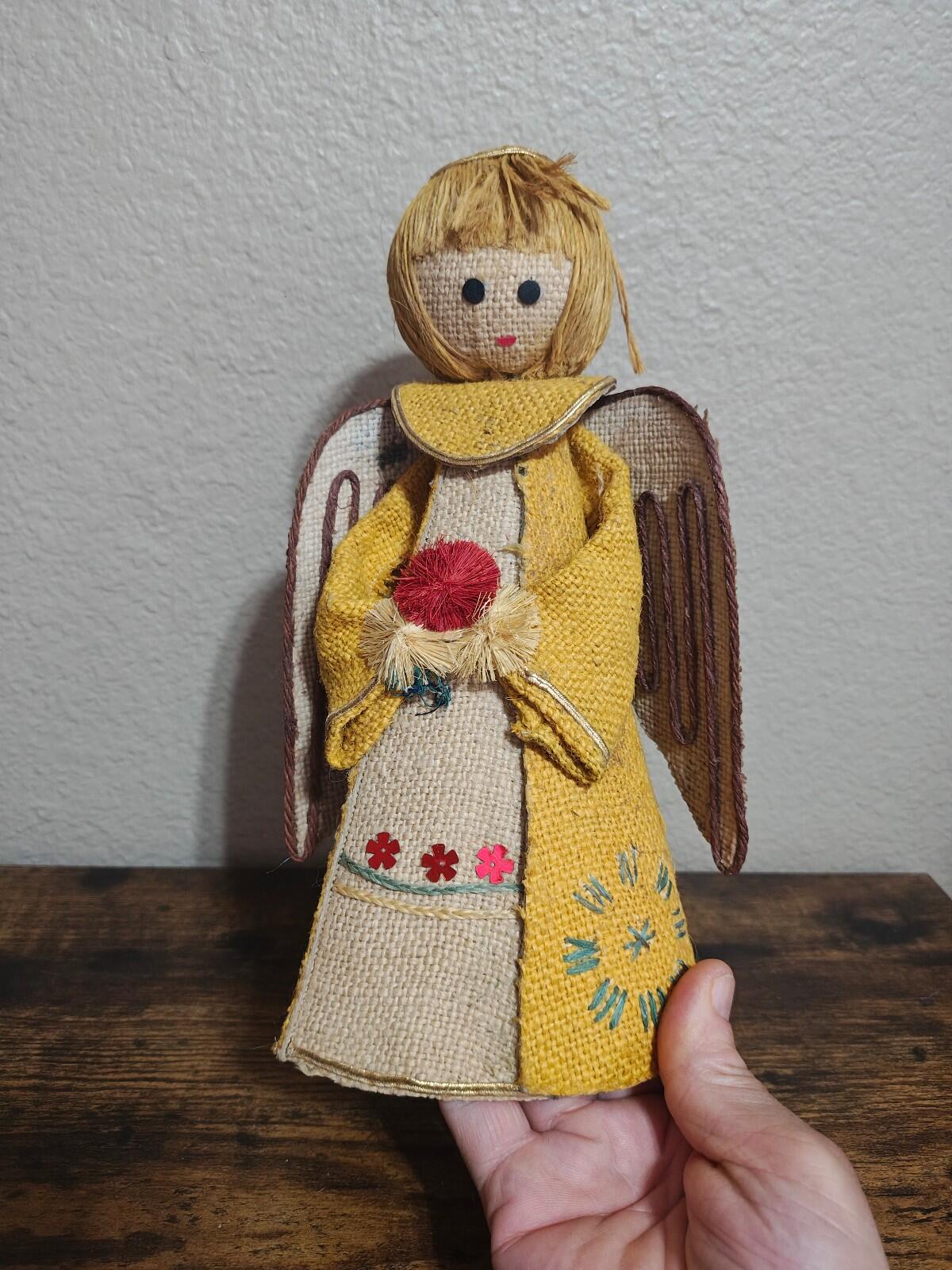 Handcrafted burlap angel doll with yellow dress, brown wings, and yarn hair.