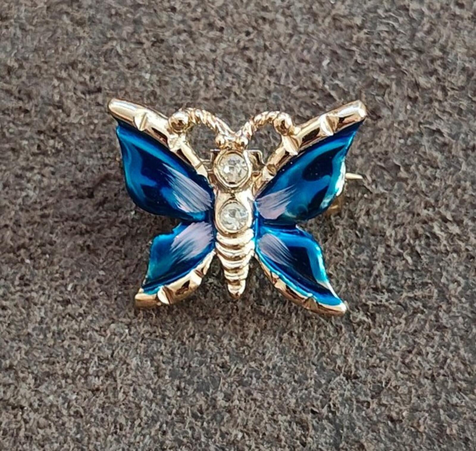Front view gold tone butterfly brooch with blue enamel wings and clear rhinestones