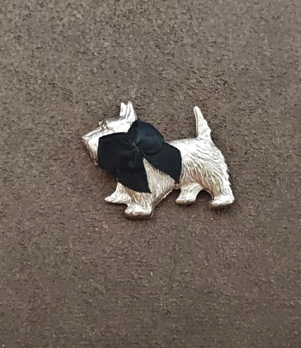 Silver-tone terrier brooch with black bow, detailed sculpted body