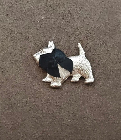 Silver-tone terrier brooch with black bow, detailed sculpted body