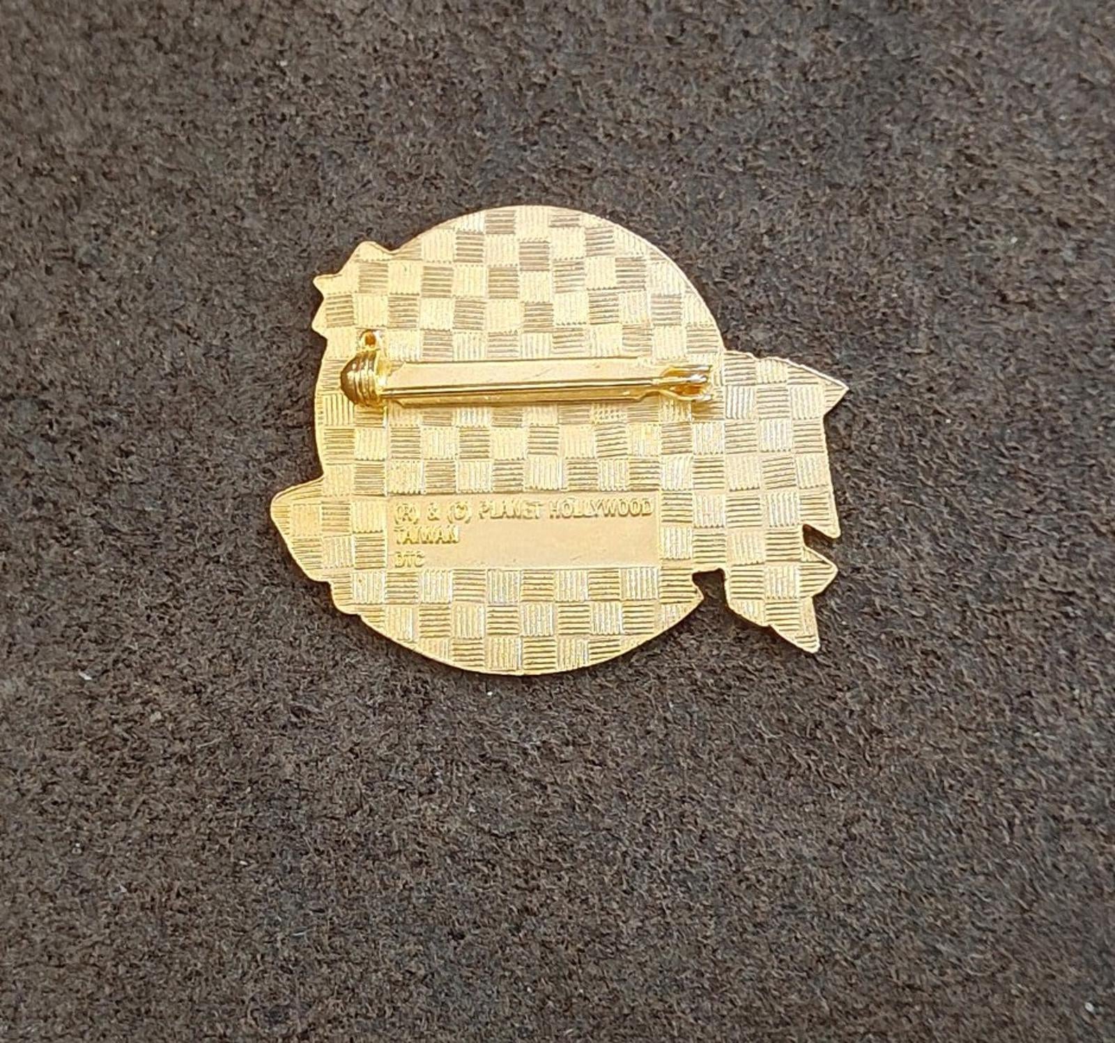 Gold-tone Planet Hollywood Honolulu enamel pin back with checkered pattern and pin post