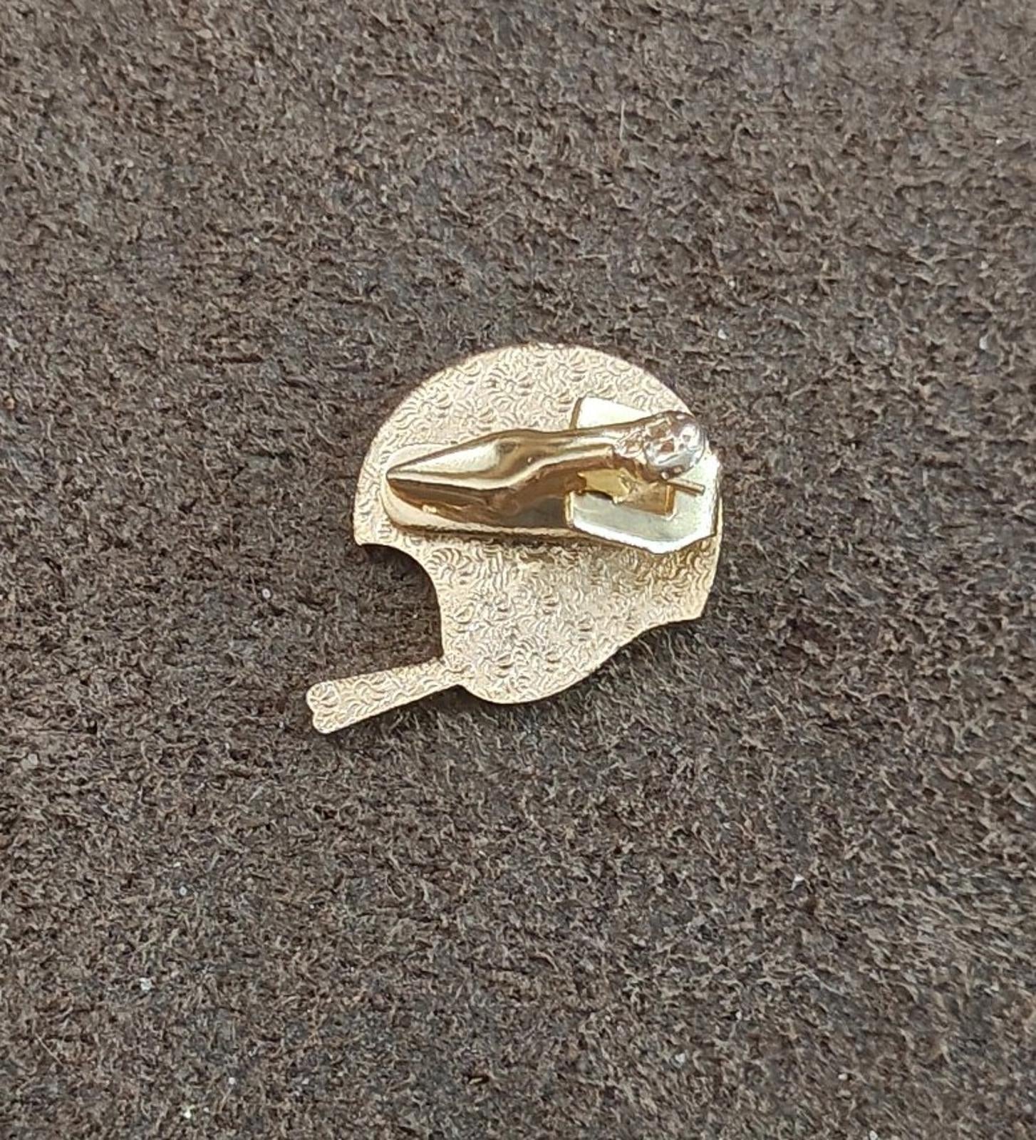 Gold-tone enamel tie clip back view with textured round gold plate