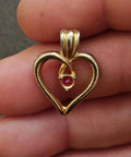 Gold-tone open heart pin with red gemstone center and loop bale