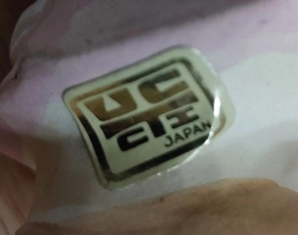 Close-up: UCTCI Japan stamp on stoneware figurine base, green and black label