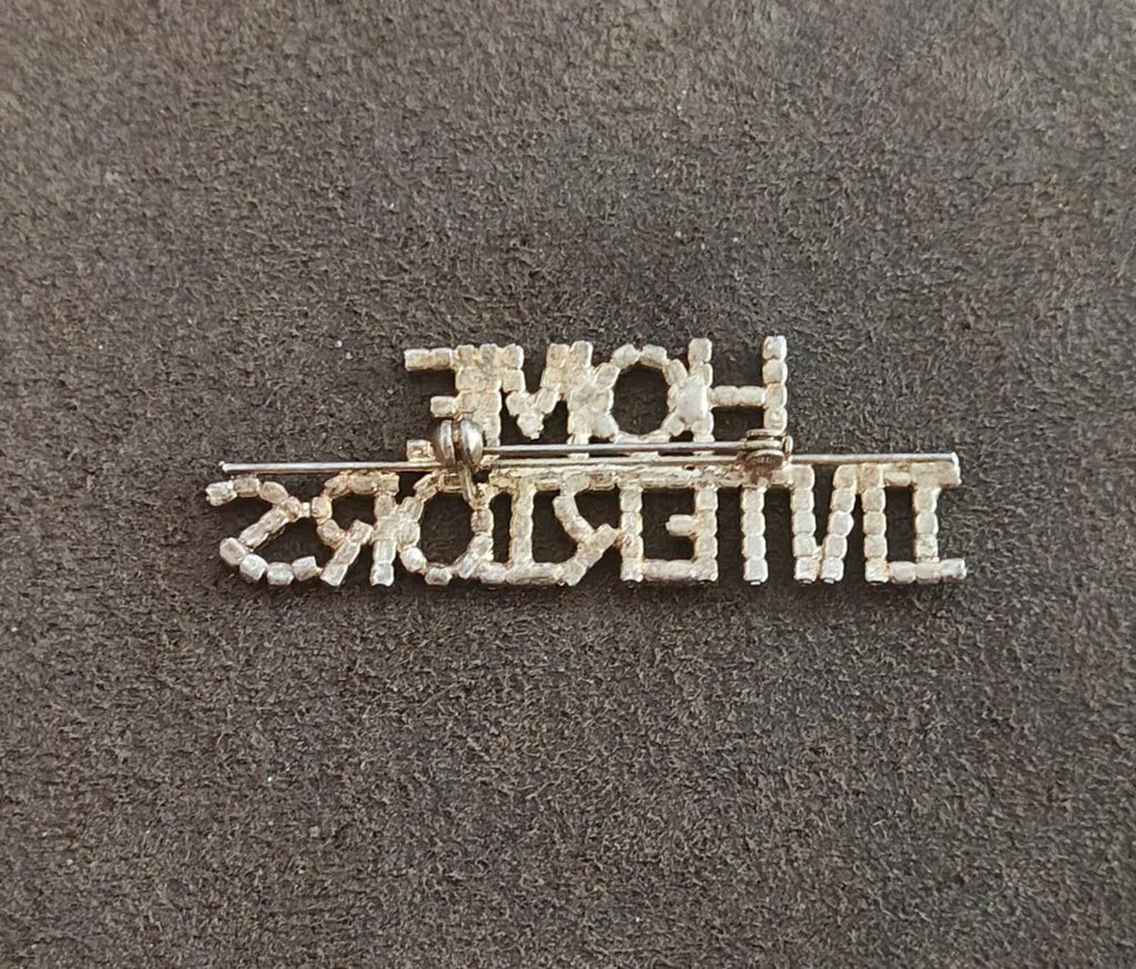 Rhinestone gold-tone brooch with pin clasp visible; "HOME INTERIORS" text