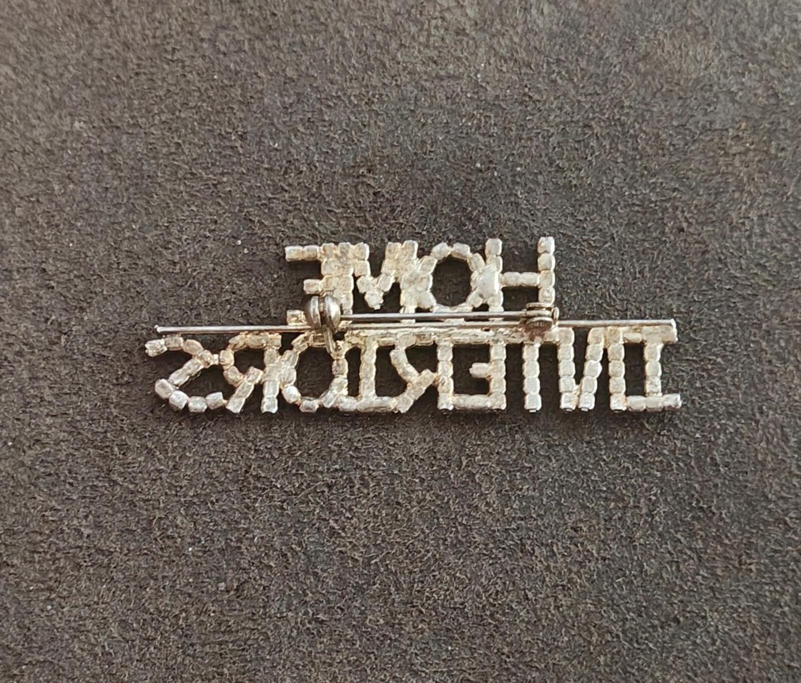Rhinestone gold-tone brooch with pin clasp visible; "HOME INTERIORS" text