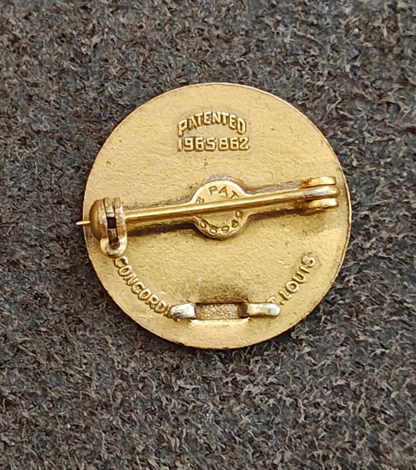 Back side of vintage gold-tone award pin, stamped "PATENTED 1958-62" and clasp hardware