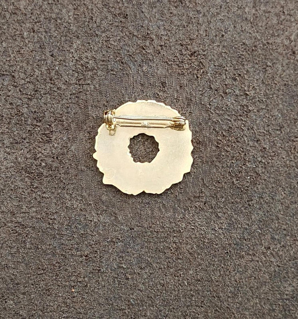 Gold-tone back of enamel Christmas wreath pin with pin clasp and circular cutout