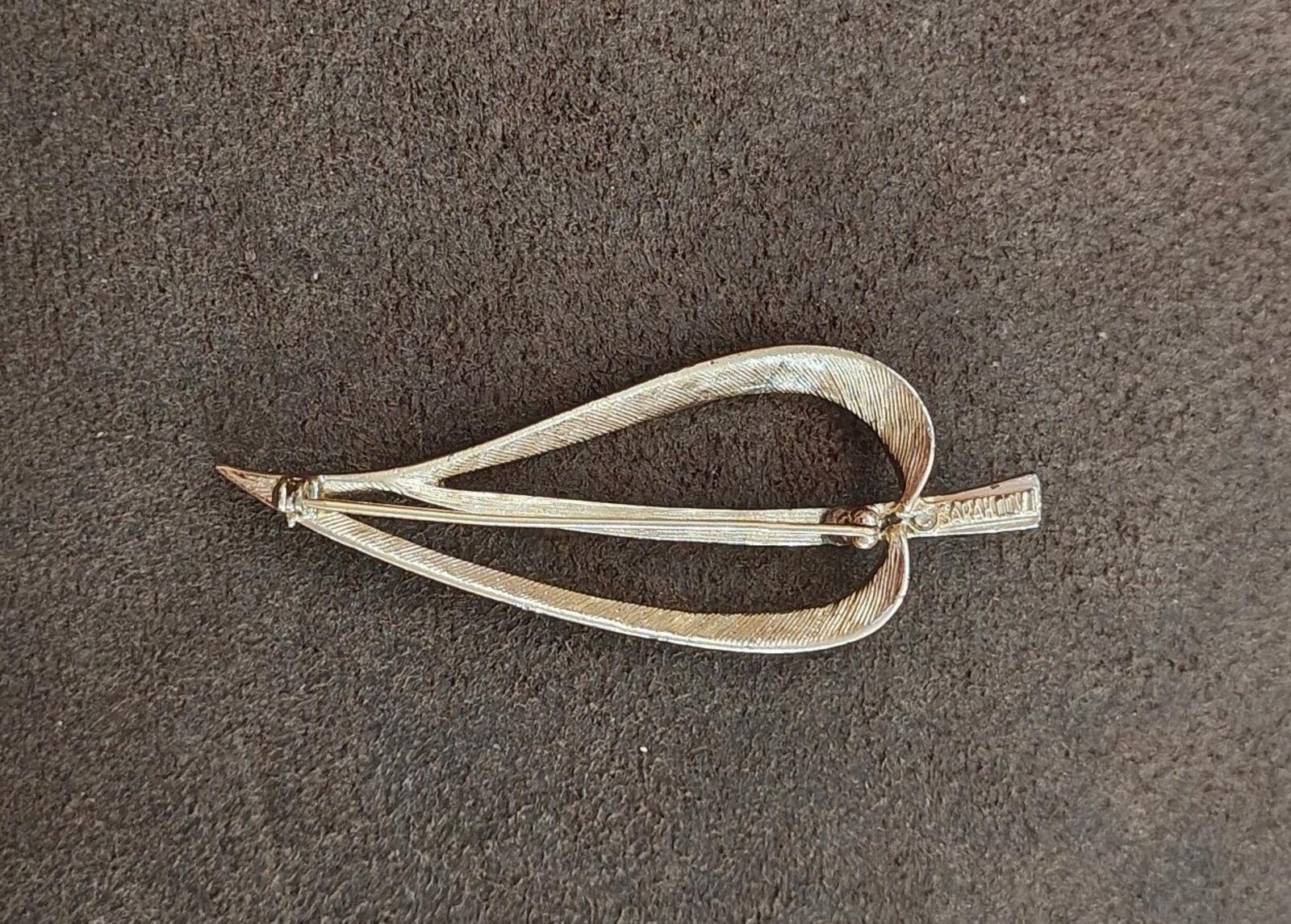 Gold open leaf brooch back view with clasp and pin channel visible.